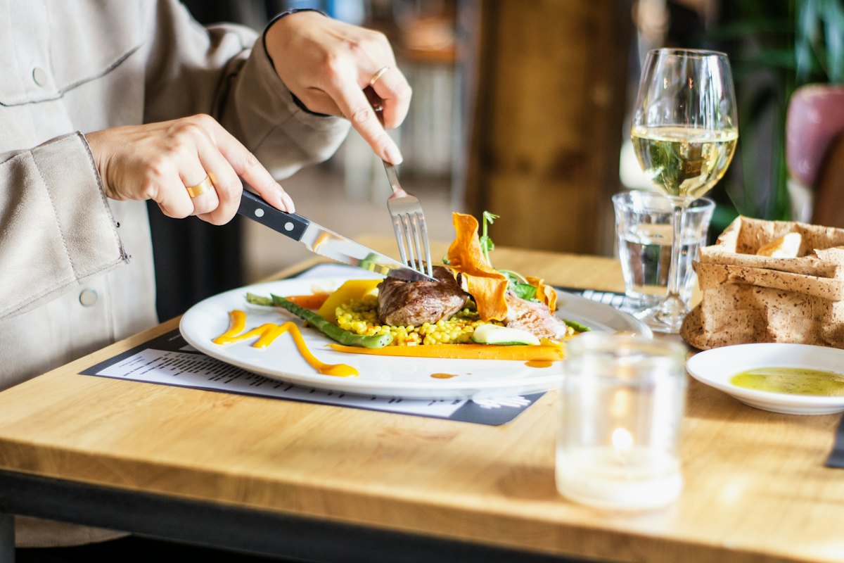 Restaurante com mesa posta e prato servido